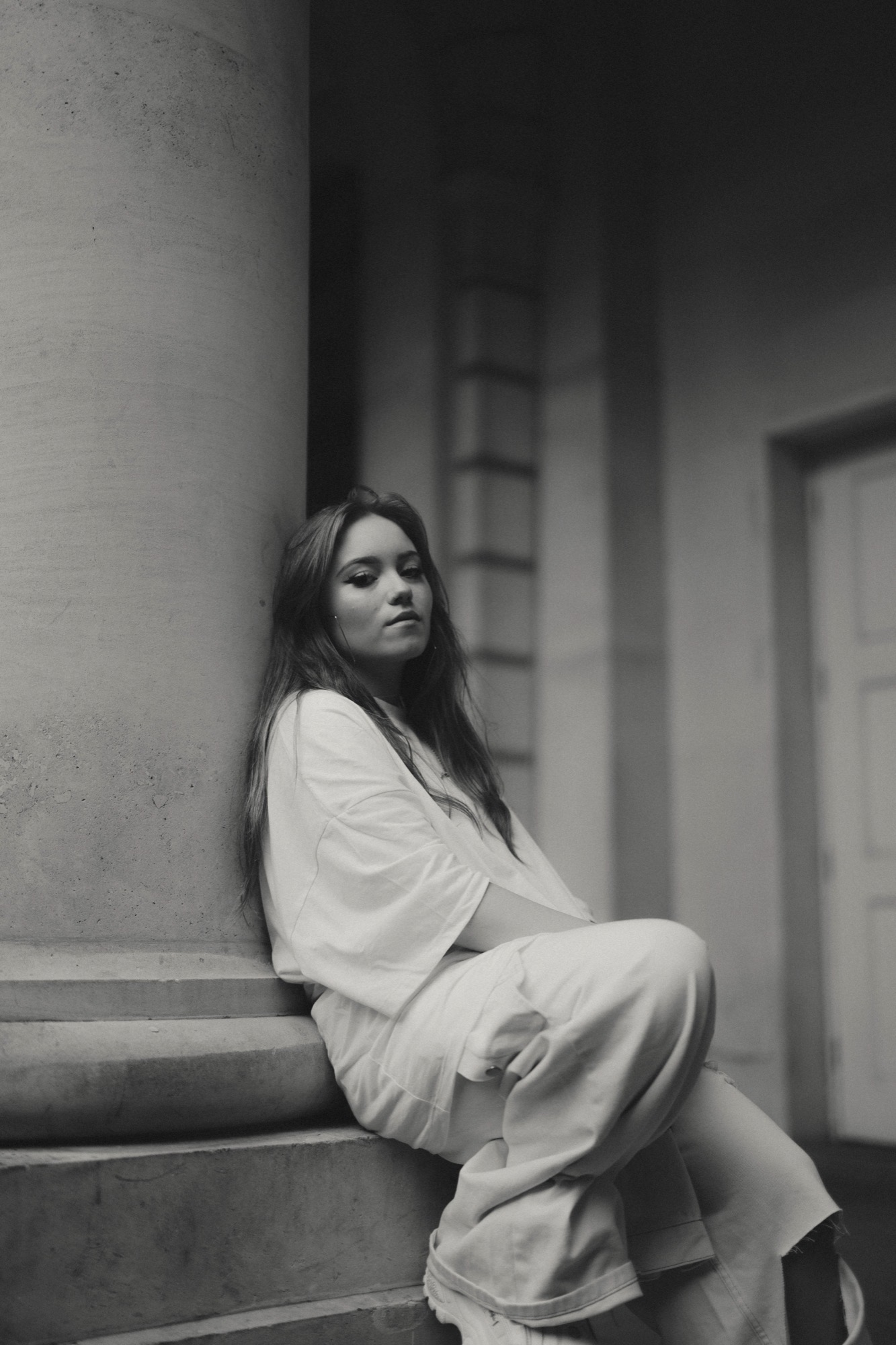 Portrait photography - woman by pillar in white outfit